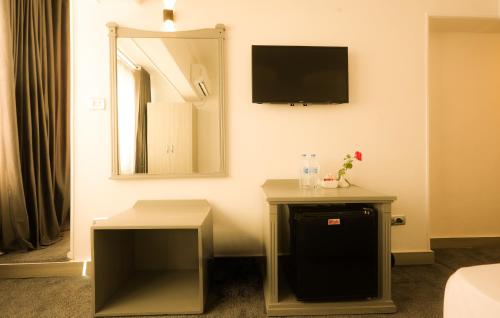 a room with two tables and a television on the wall at Aura Inn Hotel Cairo in Cairo