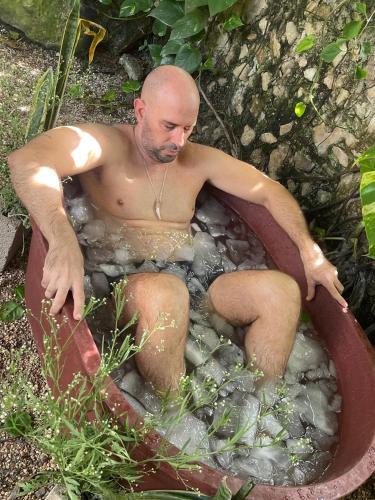 a man sitting in a bath tub at Xtambaa Cabins & Spa Only Adults in El Cuyo