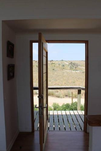 an open door to a balcony with a view at Exclusiva casa con vista panorámica al mar in Guanaqueros
