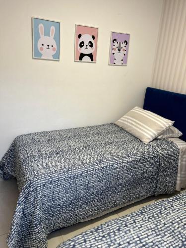 a bedroom with two beds and pictures on the wall at Apartamento Conjunto Mallorca - La Samaria - Mirolindo in Ibagué