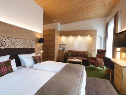 a hotel room with a bed and a living room at Das Waldhotel - Genuss & Wellness am Notschreipass in Todtnau
