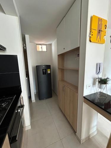 a kitchen with a black refrigerator in a room at Apartamento Conjunto Mallorca - La Samaria - Mirolindo in Ibagué