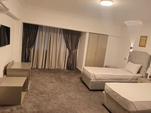 a hotel room with two beds and a couch at Aura Inn Hotel Cairo in Cairo