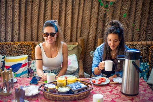 two women sitting at a table eating food at Palm Tree Villa Nungwi in Nungwi