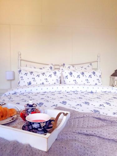a white bed with a tray of food on it at Willows Cottage on Anzac in Stanthorpe