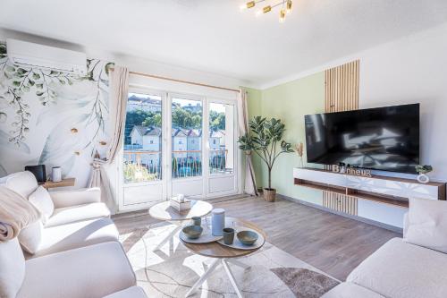 a living room with white furniture and a flat screen tv at Le Marie 115m - Spacieux 3ch' - 2 sdb - Balcon in Joeuf