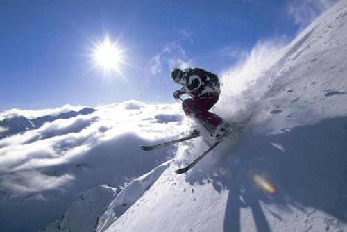 a person is skiing down a snow covered mountain at Alpenpension Elferblick in Neustift im Stubaital