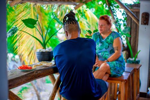 a man and a woman sitting at a table at Palm Tree Villa Nungwi in Nungwi
