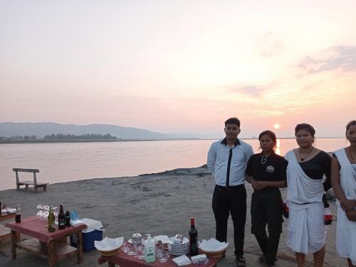 a group of people posing for a picture on the beach at Tharu Community Lodge in Kawasoti