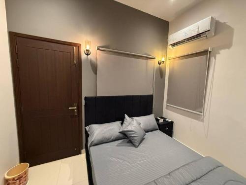 a bedroom with a bed and a brown door at Villa Oasis in Karachi