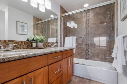 a bathroom with a shower and a sink and a tub at LakeView Queen Anne 3BR Townhome in Seattle
