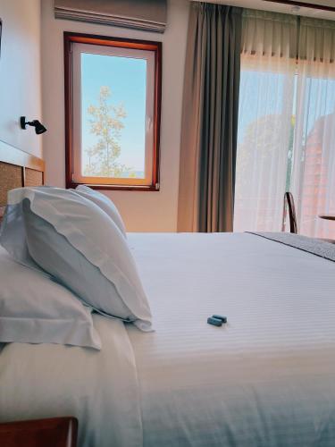 a white bed with a remote control on top of it at Hotel Termas Puyehue Wellness & Spa Resort in Puyehue