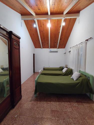 a room with four beds and a wooden ceiling at La Celeste in La Granja