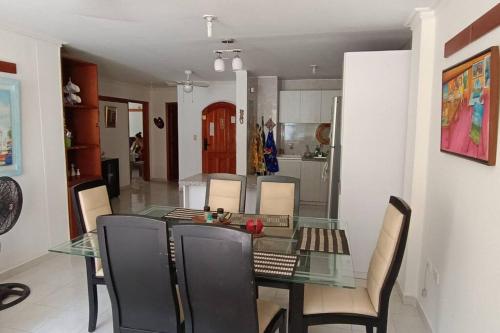 a dining room with a glass table and chairs at Apartamento en El Rodadero norte in Rodadero
