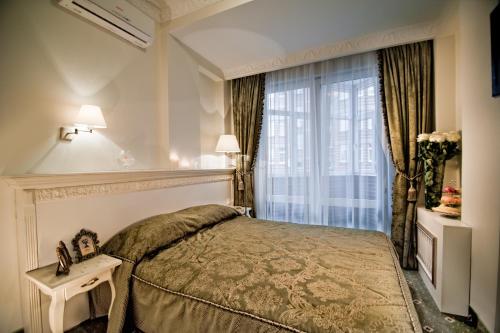 a hotel room with a bed and a window at Royal City Hotel in Kyiv