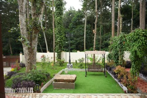 a garden with a swing and green grass at The Great Escape at Yercaud in Yercaud
