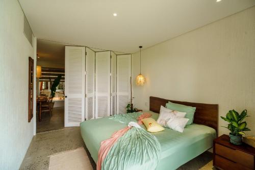 a bedroom with a green bed with white pillows at Camfusion House in Hoi An