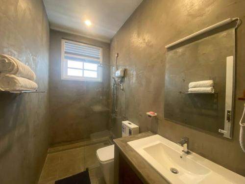 un bagno con lavandino, water e finestra di Villa 59- Luxurious Beach house in Ambalangoda a Ambalangoda