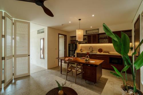 a kitchen with a wooden table in a room at Camfusion House in Hoi An