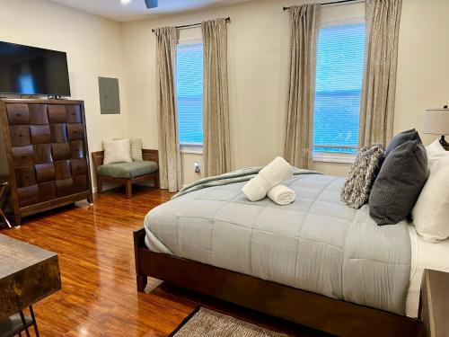 a bedroom with a large bed and two windows at Saugerties Waterfront Getaway in Saugerties