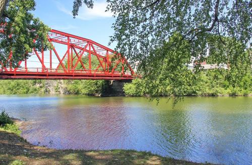 a red bridge over a river with water at Saugerties Waterfront Getaway in Saugerties