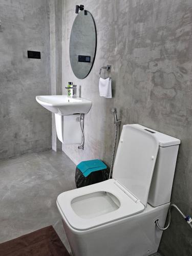 a bathroom with a white toilet and a sink at Muthu Sea View Hiriketiya in Hiriketiya