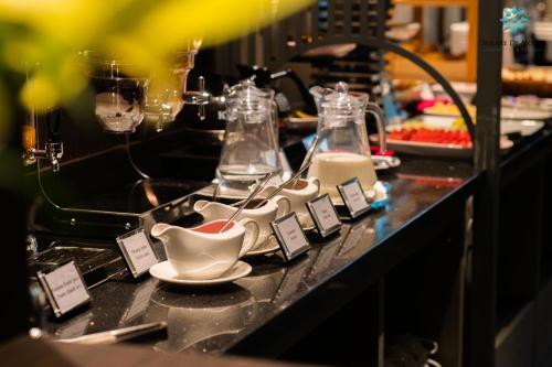 a buffet line with glasses and dishes on a counter at Solare De Monte Hotel & Spa in Hanoi