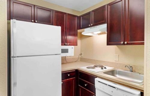 a kitchen with a white refrigerator and a sink at Extended Stay America Suites - Dallas - Plano in Plano