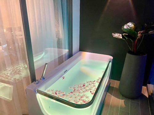 a bath tub with flowers in it in a bathroom at The Blue Hotel - SHA Plus in Chalong 