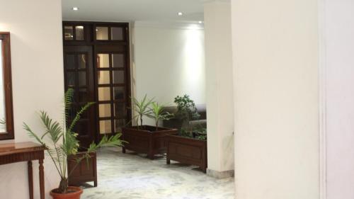 a hallway with potted plants in a building at Hotel Alpana in Haridwār