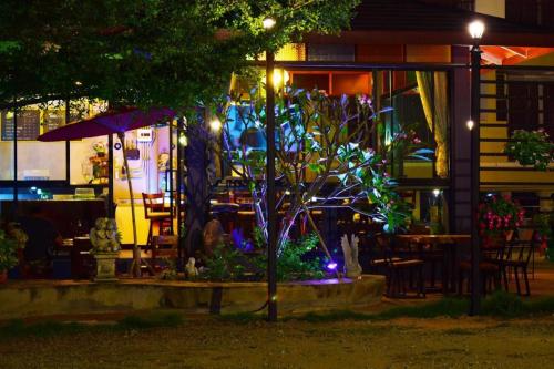 a tree in front of a restaurant at night at Nantharom Hotel and Restaurant in Chachoengsao