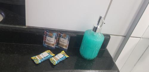 a blue toothbrush in a blue bottle on a counter at Apartamento joia rara no coração do Sudoeste in Brasilia