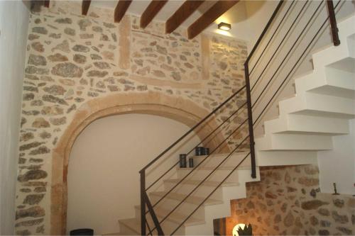 a staircase in a house with a stone wall at Petit Hotel C'an Mel in Caʼs Concos