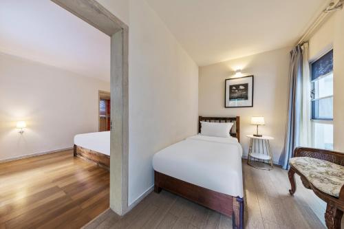 a bedroom with two beds and a window at 6號花園別墅酒店 Shenzhen No'6 Garden Villa --French Window with garden view,Close to Sea World &Shekou Ferry Port &K11 Ecoast &Subway Nearby ,Offer Western food and coffee &English speaking with tour services in Shenzhen