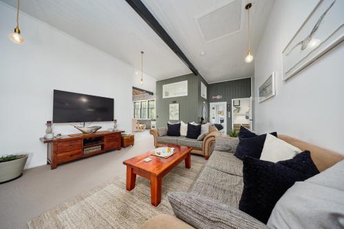 a living room with a couch and a tv at The Loft House in Kaikoura