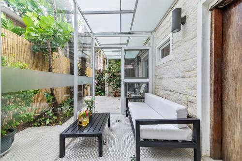 a patio with a white couch and a table at 6號花園別墅酒店 Shenzhen No'6 Garden Villa --French Window with garden view,Close to Sea World &Shekou Ferry Port &K11 Ecoast &Subway Nearby ,Offer Western food and coffee &English speaking with tour services in Shenzhen