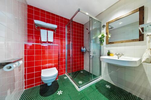 a red tiled bathroom with a toilet and a sink at 6號花園別墅酒店 Shenzhen No'6 Garden Villa --French Window with garden view,Close to Sea World &Shekou Ferry Port &K11 Ecoast &Subway Nearby ,Offer Western food and coffee &English speaking with tour services in Shenzhen