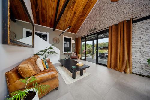a living room with a leather couch and a table at The Loft House in Kaikoura