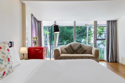 a bedroom with a bed and a chair and a window at 6號花園別墅酒店 Shenzhen No'6 Garden Villa --French Window with garden view,Close to Sea World &Shekou Ferry Port &K11 Ecoast &Subway Nearby ,Offer Western food and coffee &English speaking with tour services in Shenzhen