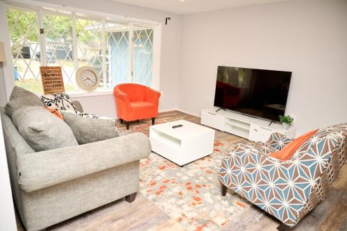 a living room with a couch and a tv at Home away from Home in Waldorf