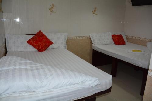 2 Betten in einem Zimmer mit roten Kissen darauf in der Unterkunft Everest Hostel in Hongkong