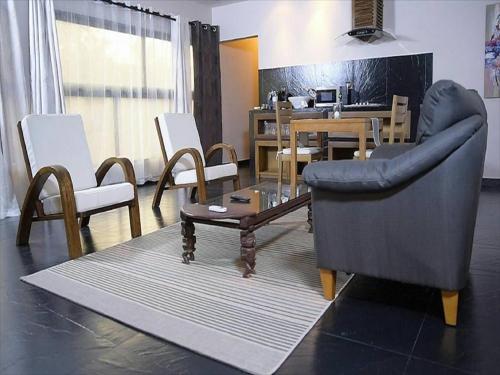 a living room with a couch and a table and chairs at Le Patio in Lomé