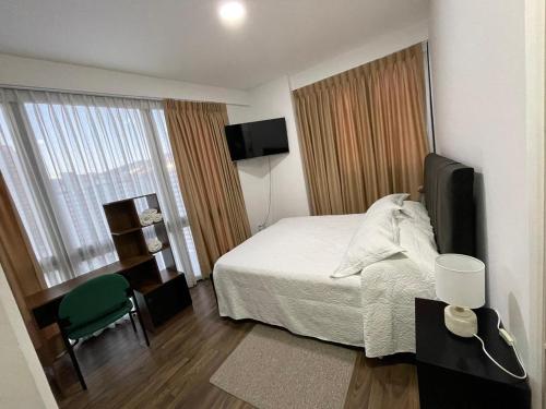 a small hotel room with a bed and a television at Departamento completo Sopocachi in La Paz