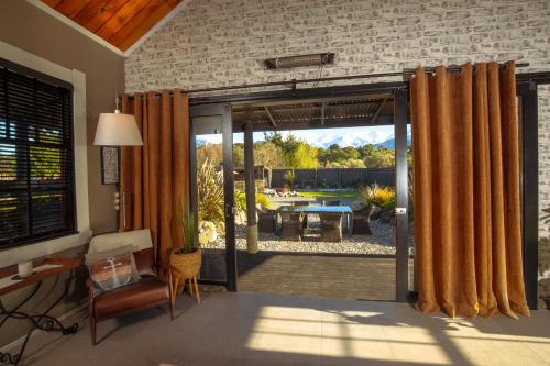 a living room with a sliding glass door to a patio at The Loft House in Kaikoura