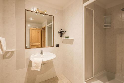 a white bathroom with a sink and a shower at Stelvio Residence in Trafoi