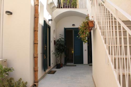 an alley with a green door and stairs at Casa Marsalia in Marsala