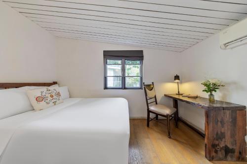 a bedroom with a bed and a desk with a chair at 6號花園別墅酒店 Shenzhen No'6 Garden Villa --French Window with garden view,Close to Sea World &Shekou Ferry Port &K11 Ecoast &Subway Nearby ,Offer Western food and coffee &English speaking with tour services in Shenzhen