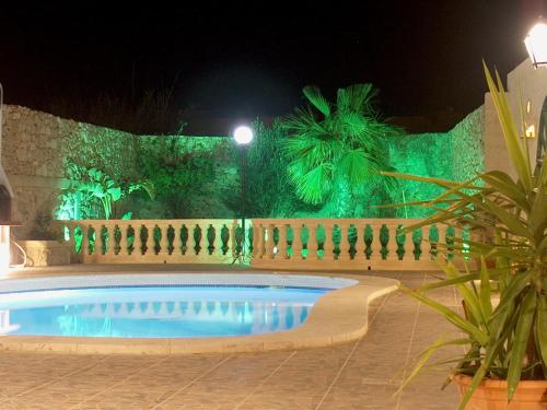a swimming pool in a yard at night at Barumbara Farmhouse in Sannat