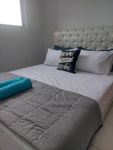 a white bed with a silver headboard and pillows on it at KLIA Travel Homestay - 3R 2B - WIFI & NETFLIX in Sepang