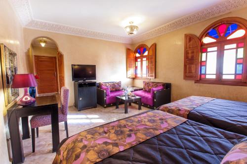 a hotel room with two beds and a living room at Riad Andalib in Fès